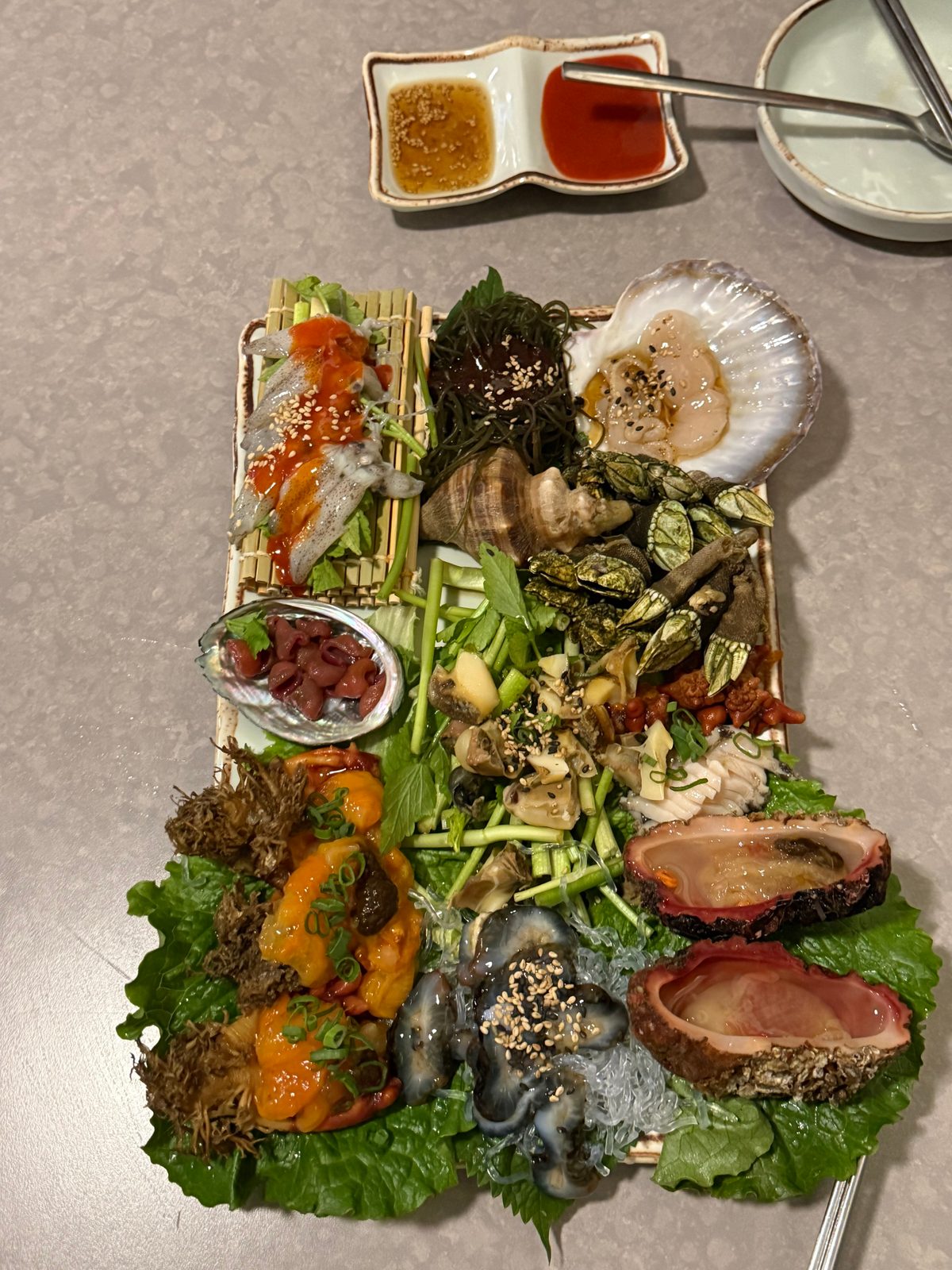 긴 접시에 여러 가지 해산물을 빼곡하게 담은 제철 모듬