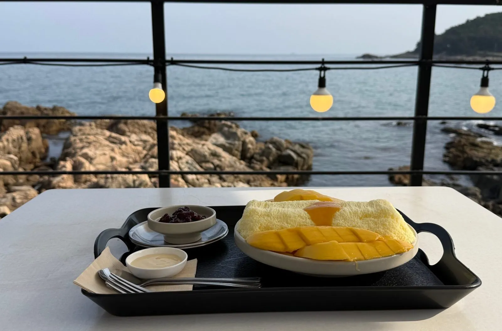 바다가 보이는 테라스 테이블에 놓인 망고 빙수 쟁반