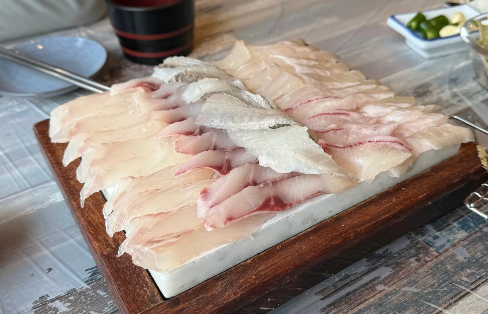 Thick slices of white fish laid out neatly on a wooden board