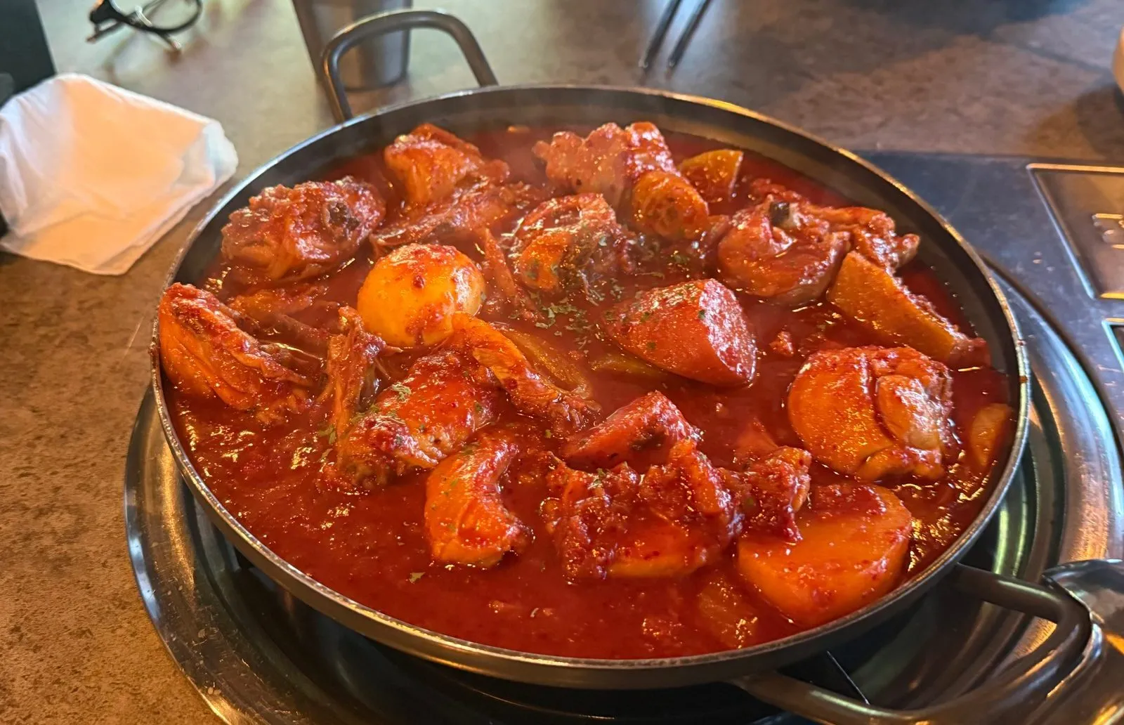 Chicken stew with aged kimchi in red sauce, cooked in a wide pot