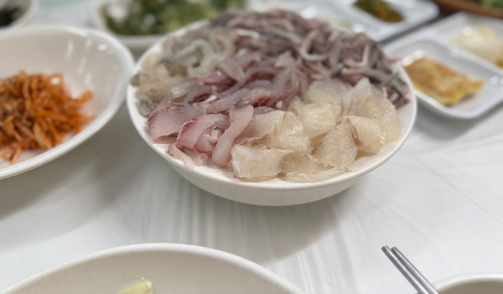 Assorted sashimi and gizzard shad heaped in a white bowl