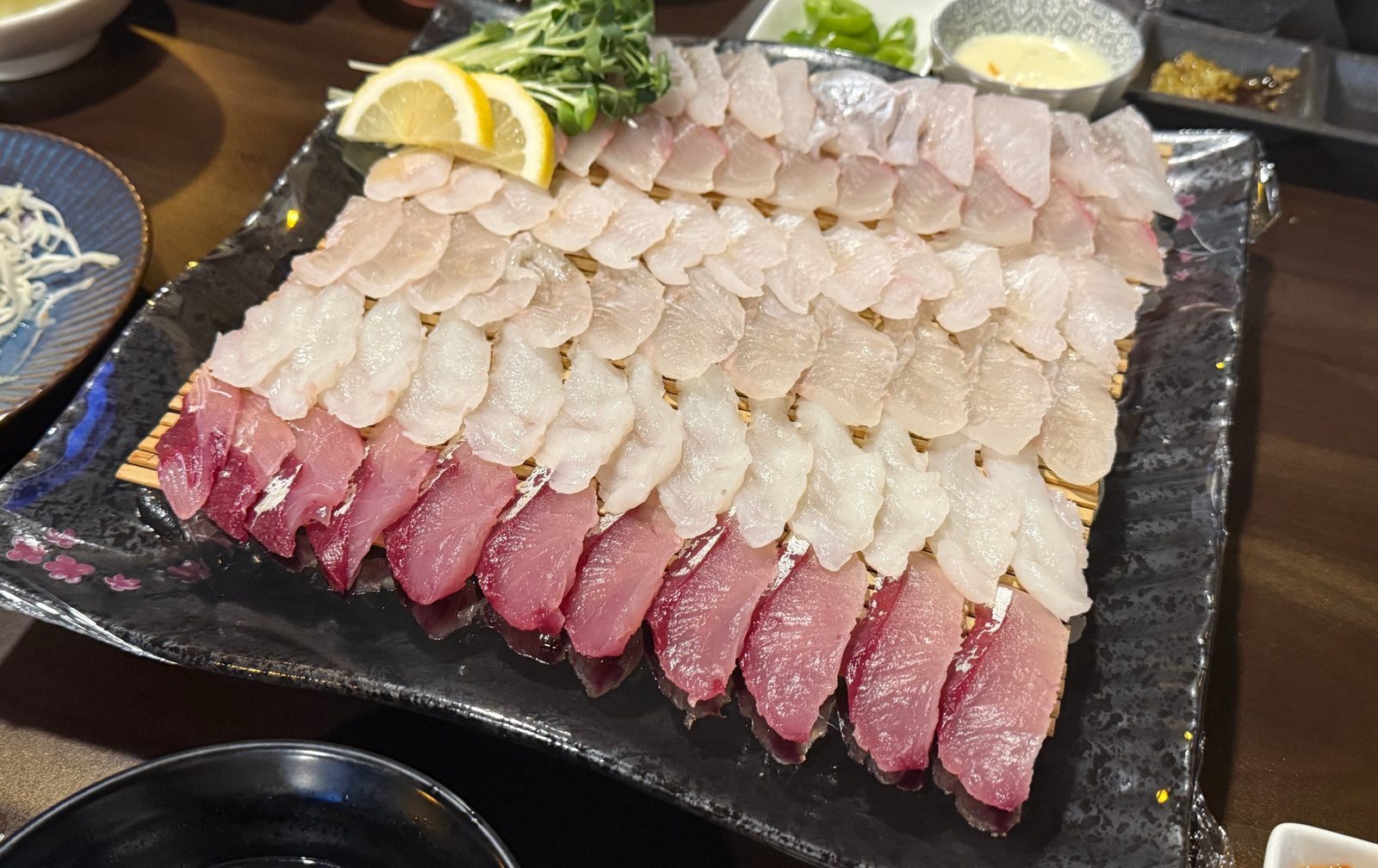 네모난 접시에 줄을 맞춰 담은 모둠회와 레몬