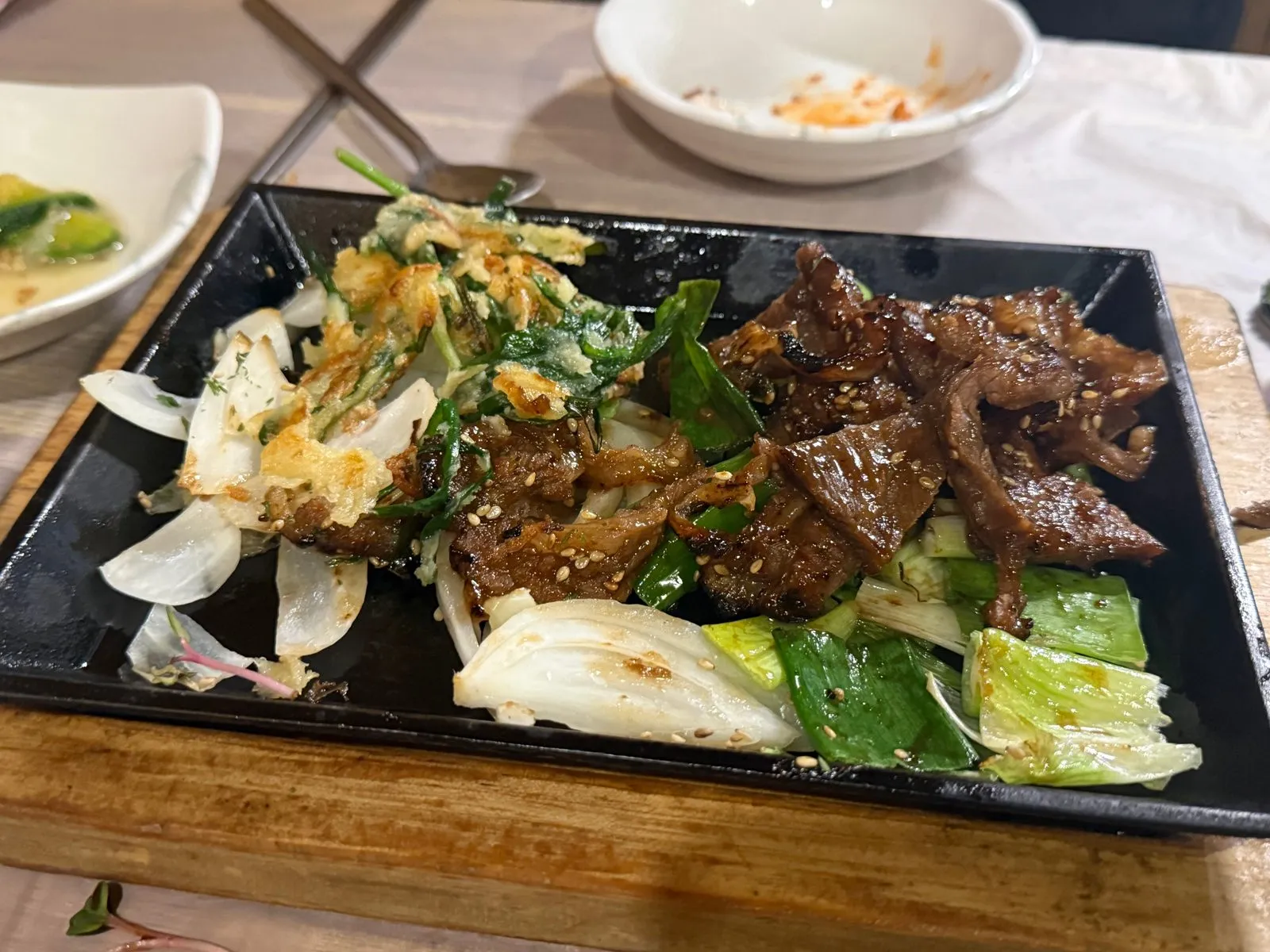 검은 철판에 채소와 함께 담긴 구운 LA갈비
