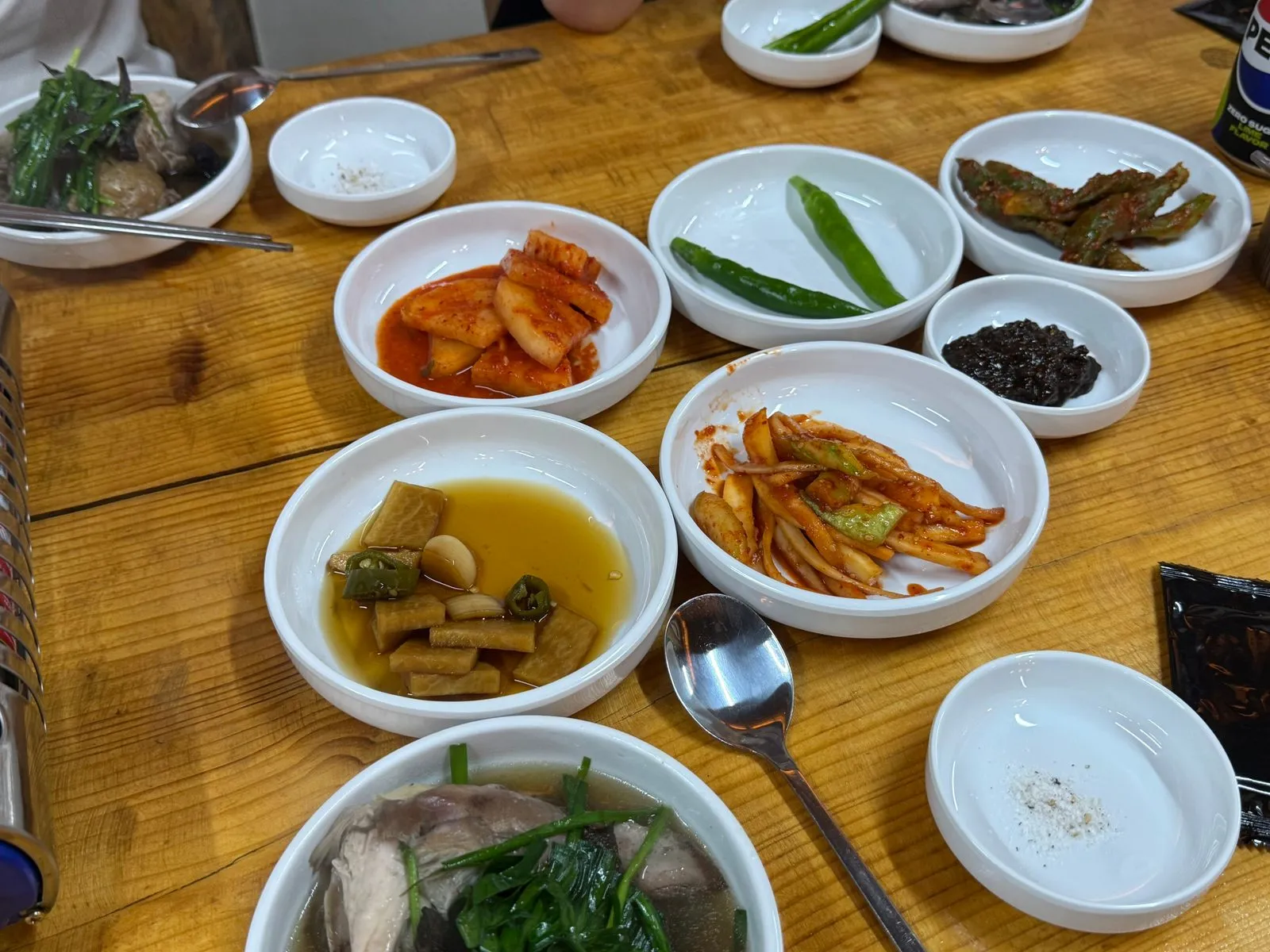 Side dishes such as kimchi, peppers, and pickles in small dishes