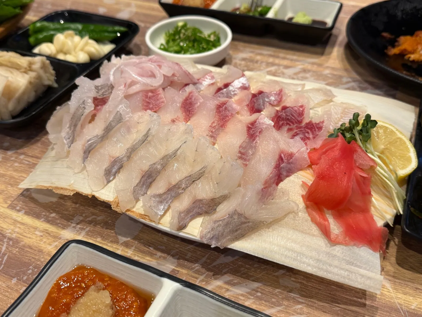 An assorted sashimi platter spread across a large plate