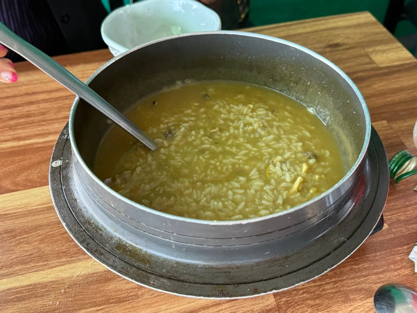 솥에 담겨 나온 노란빛의 전복죽과 국자
