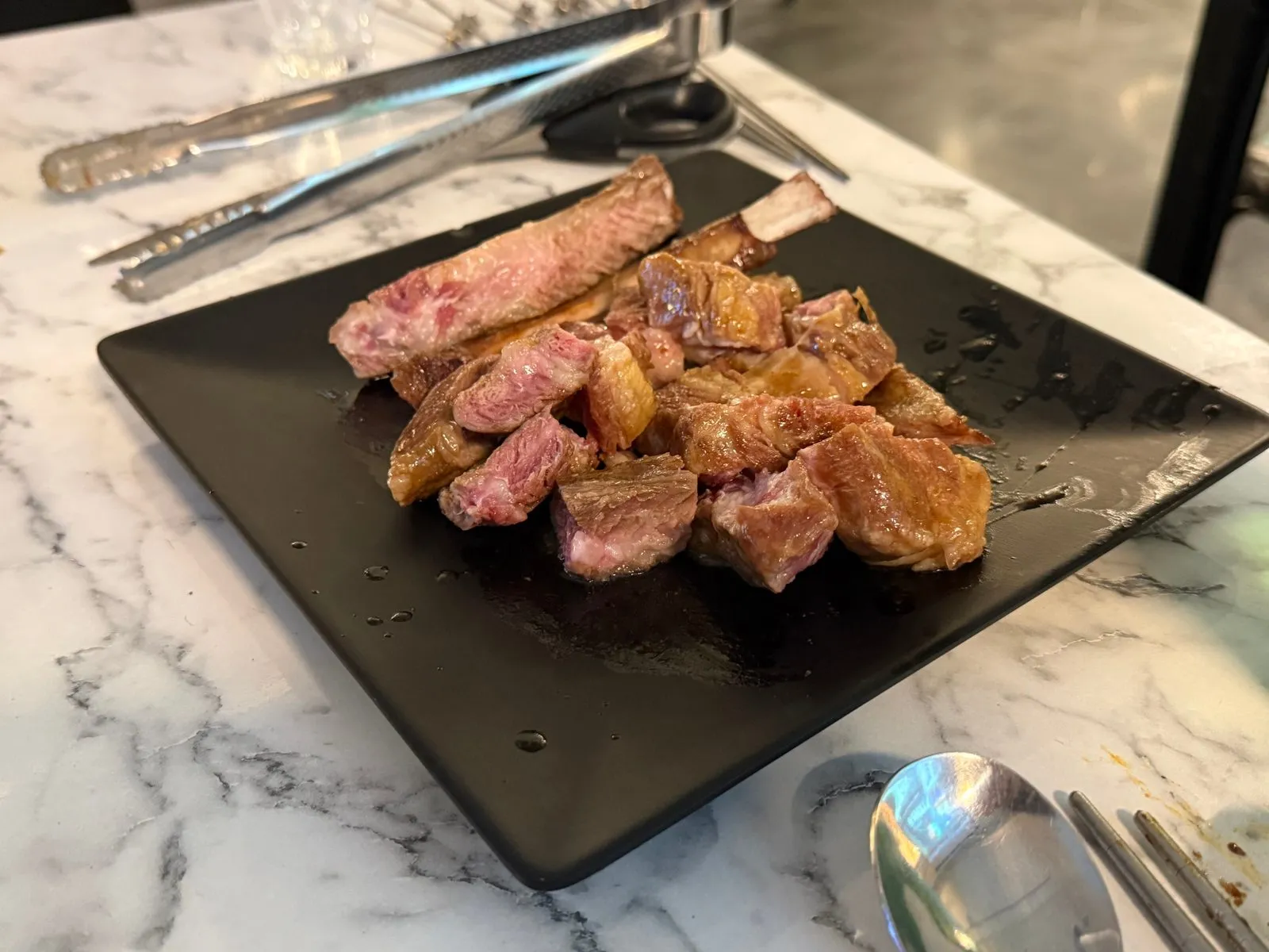 Pre-grilled lamb ribs on the bone on a black plate