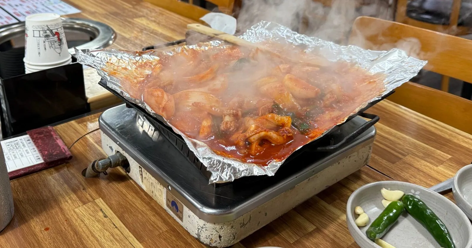 휴대용 버너 위 은박지에서 김을 내며 익는 양념구이
