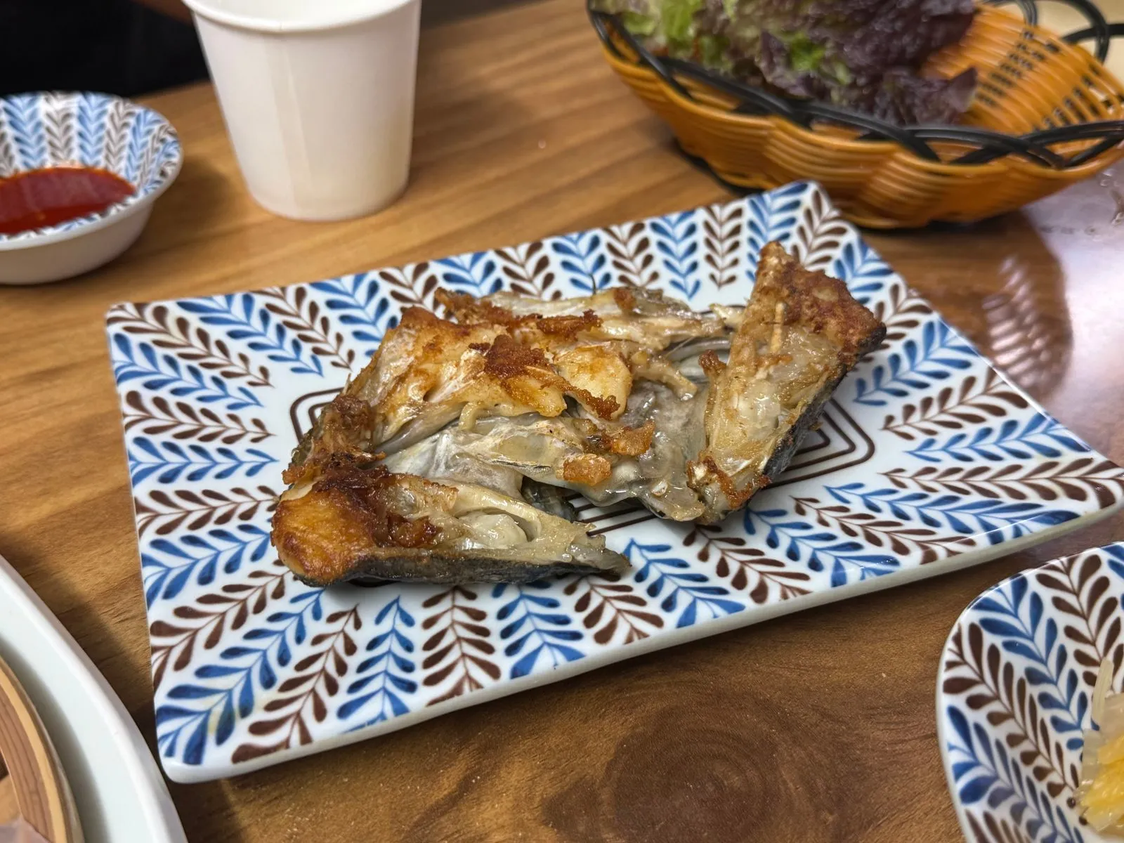 무늬가 있는 네모난 접시에 담긴 구운 생선 머리